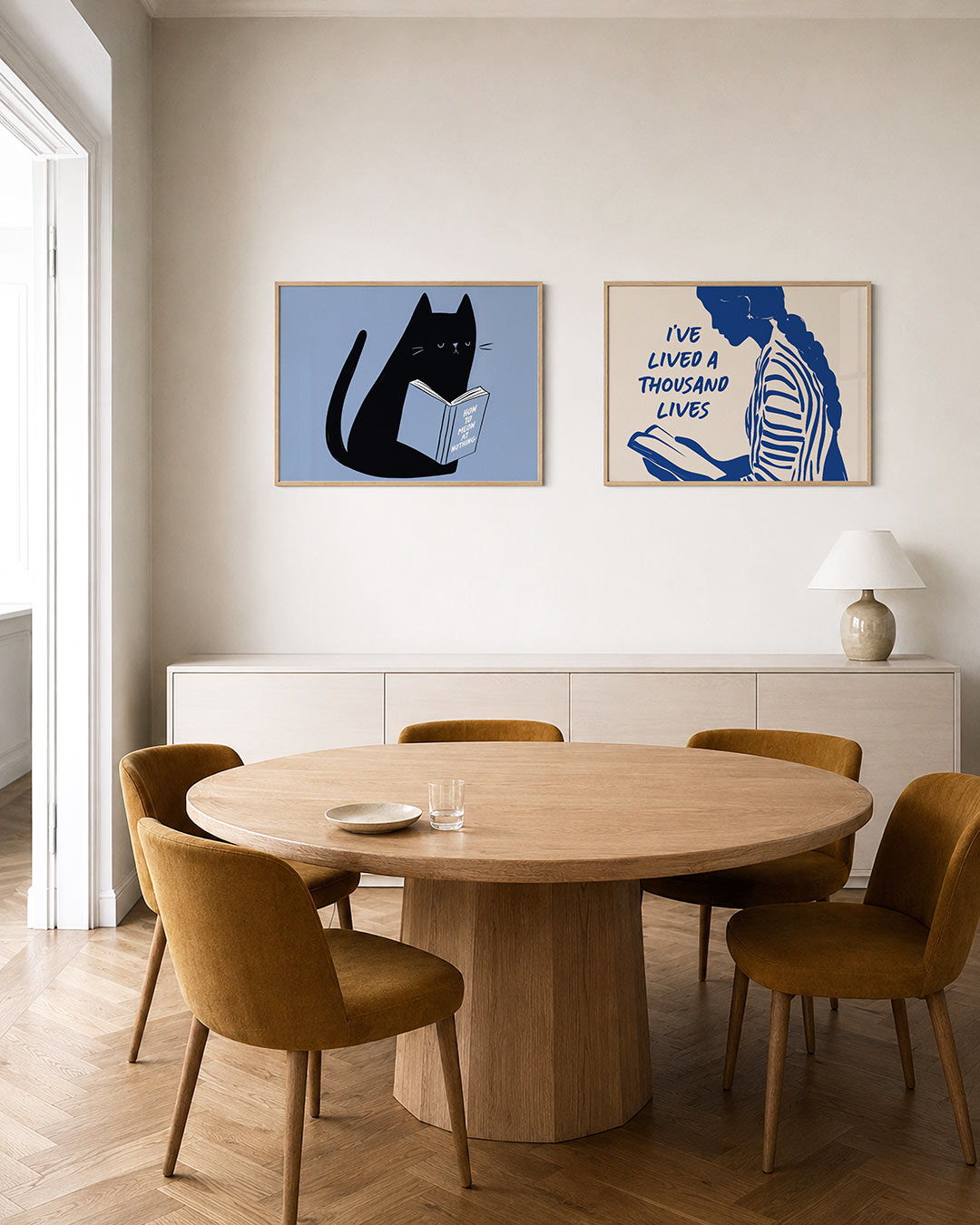 Interieurpresentatie van twee posters met een zwarte kat met een boek op een lichtblauwe achtergrond