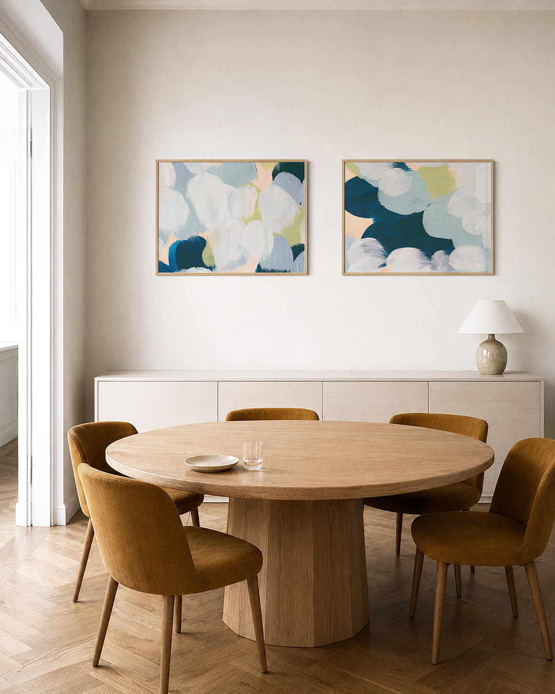 Interieurbeeld met twee liggende posters: zachte penseelstreken in blauw, groen en wit