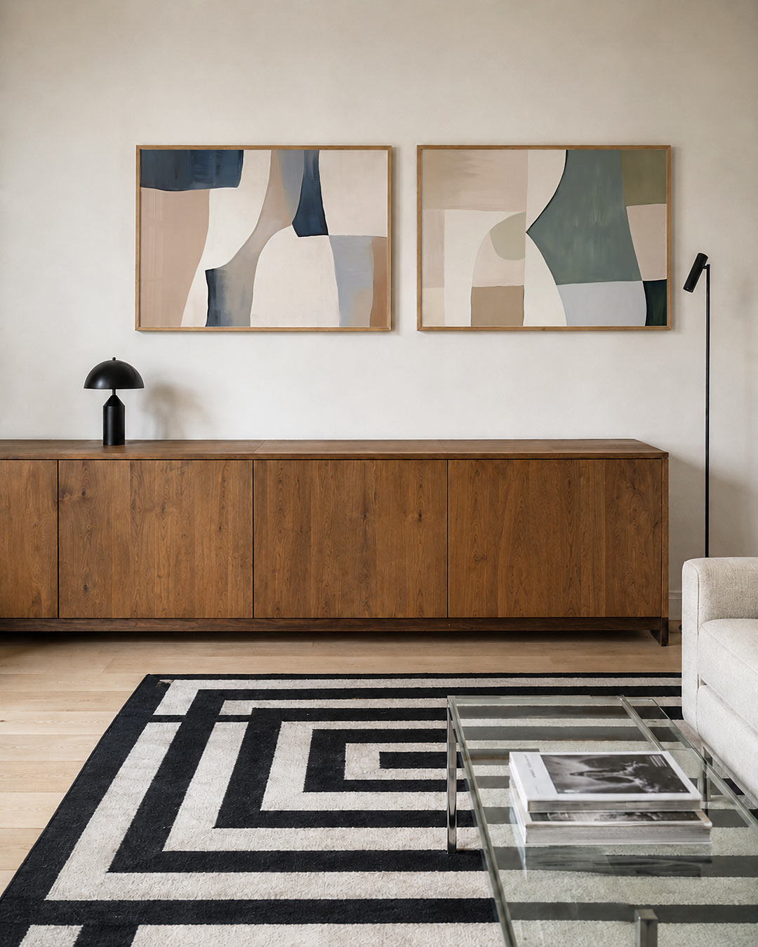 Twee liggende posters met zachte, vloeiende vormen in beige, wit en blauwgrijs, aan de muur in een interieur
