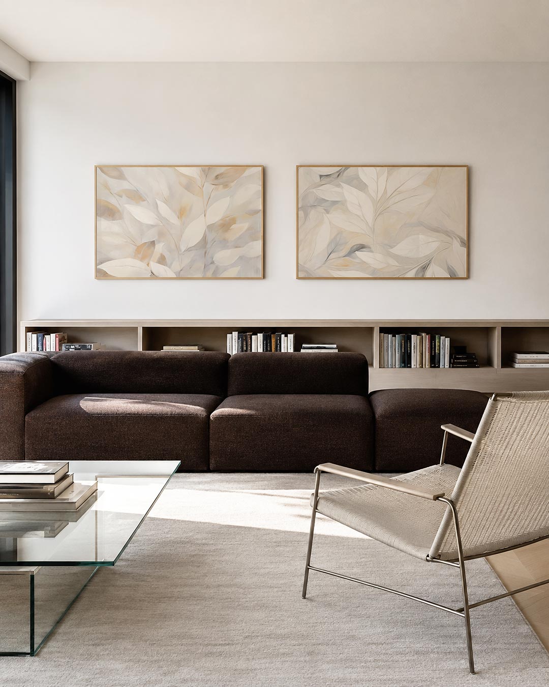 Twee liggende posters met een fijn spel van zachte bladeren in crèmekleuren, aan de muur in een interieur