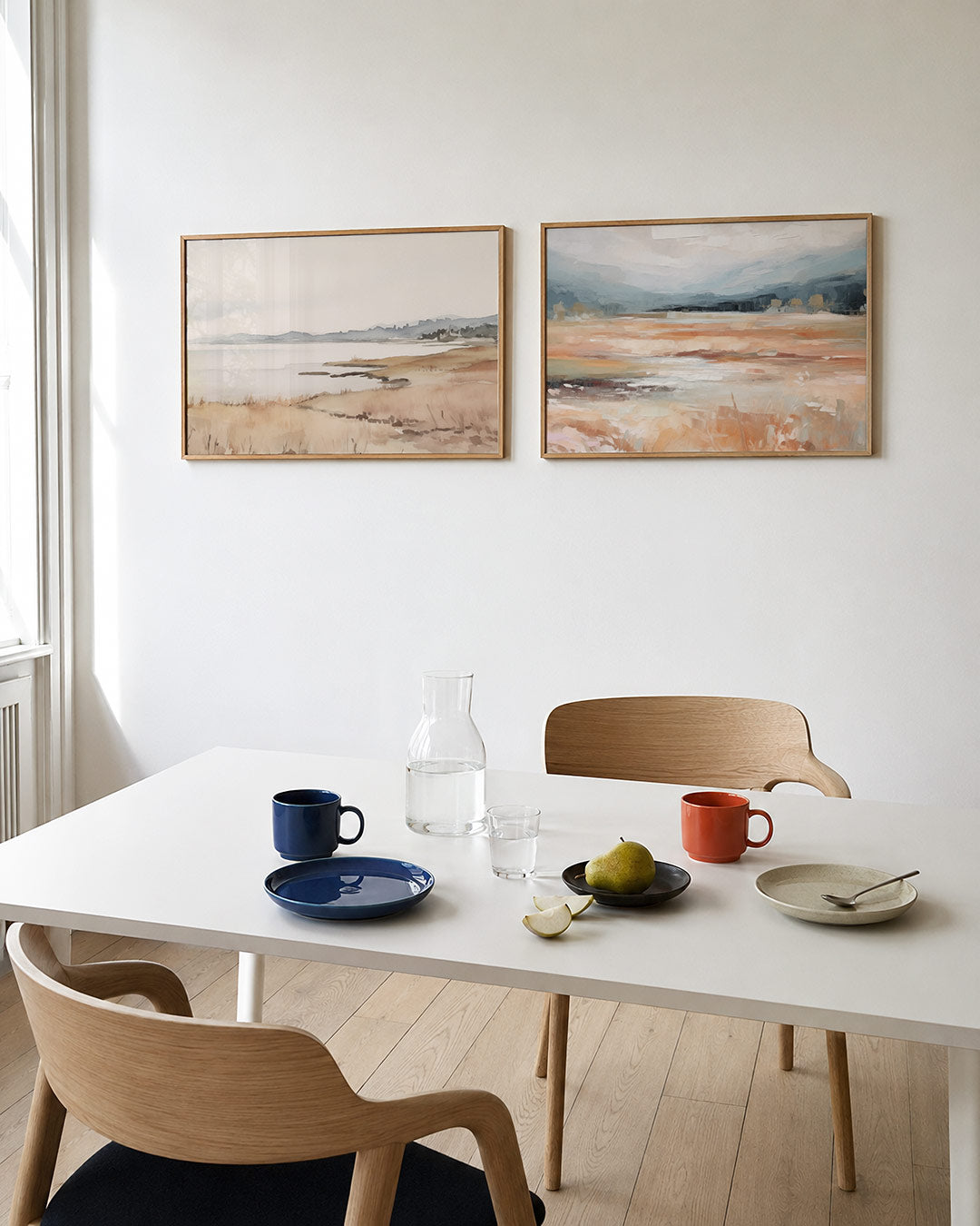 Tweedelige posterset met een kustlijn in zachte tinten van beige en blauw, getoond in een interieur