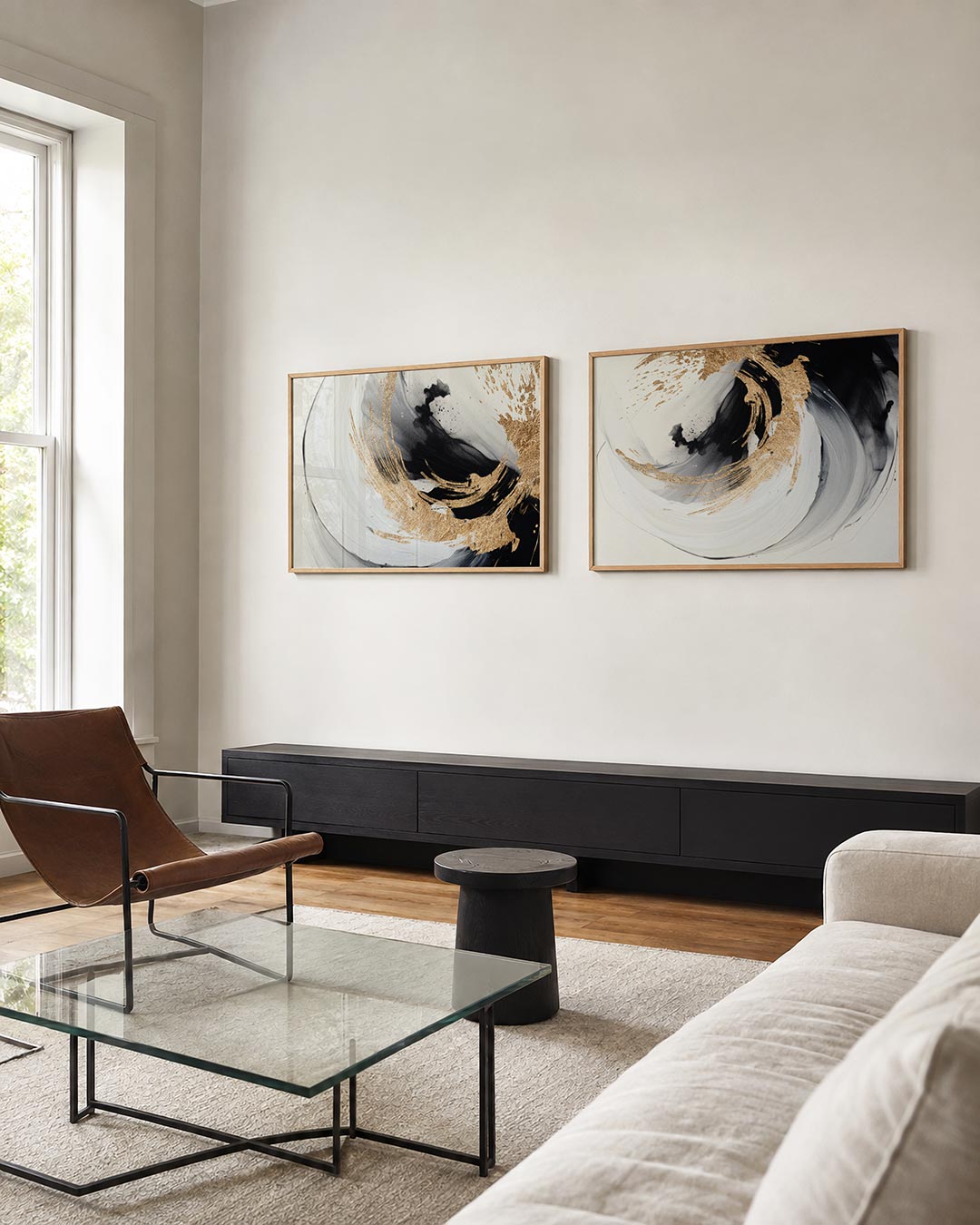 Twee liggende posters met zwarte en witte penseelstreken met gouden accenten, aan de muur in een interieur