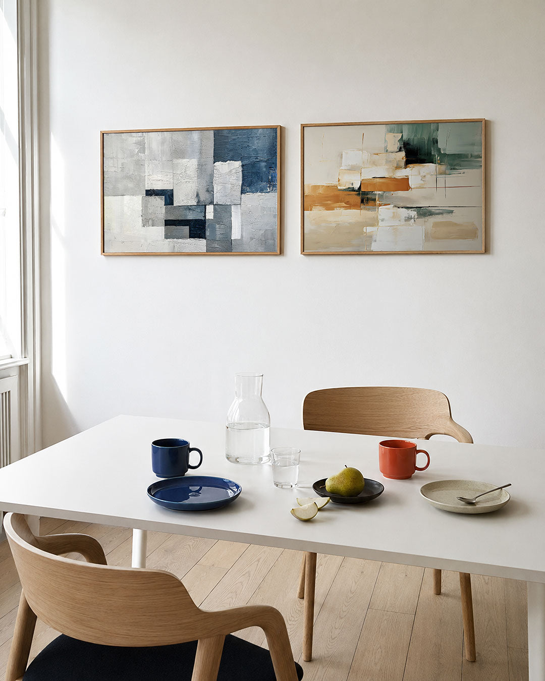 Twee liggende posters met een spel van rechthoeken in grijstinten en blauw, aan de muur in een interieur
