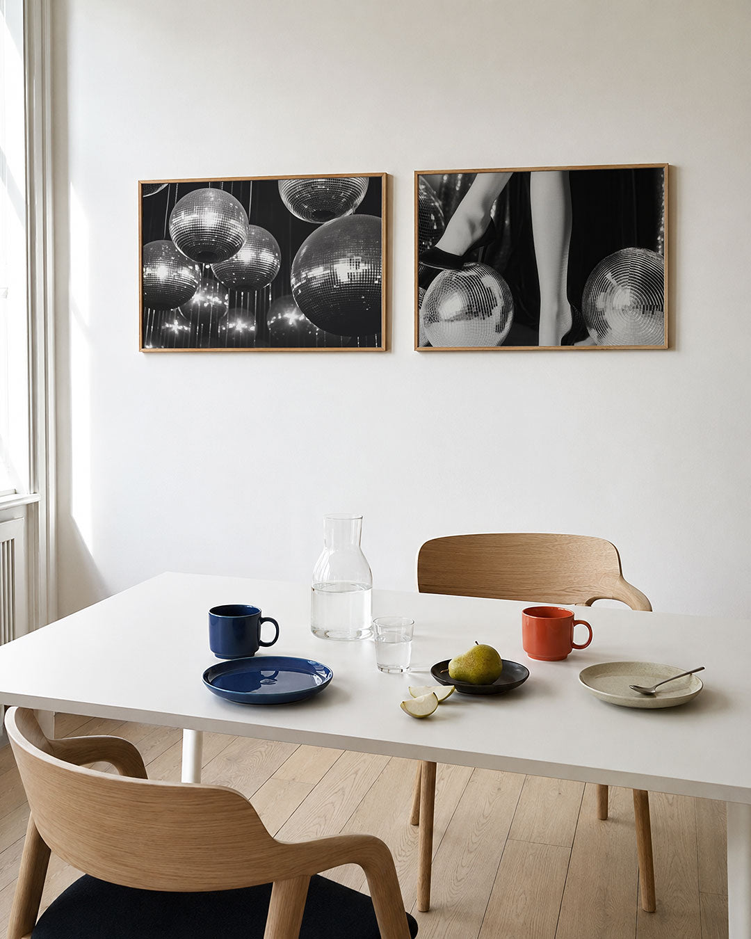 Twee liggende posters met een verzameling glanzende bollen die zweven in een donkere ruimte, aan de muur in een interieur