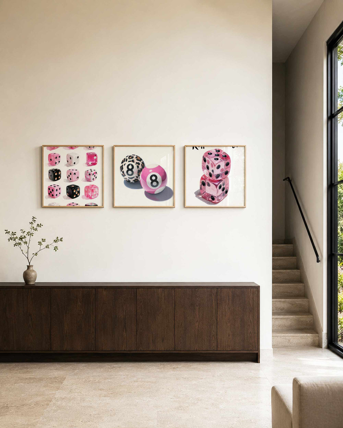 Interieurpresentatie van een driedelige vierkante posterset met roze dobbelstenen postersет