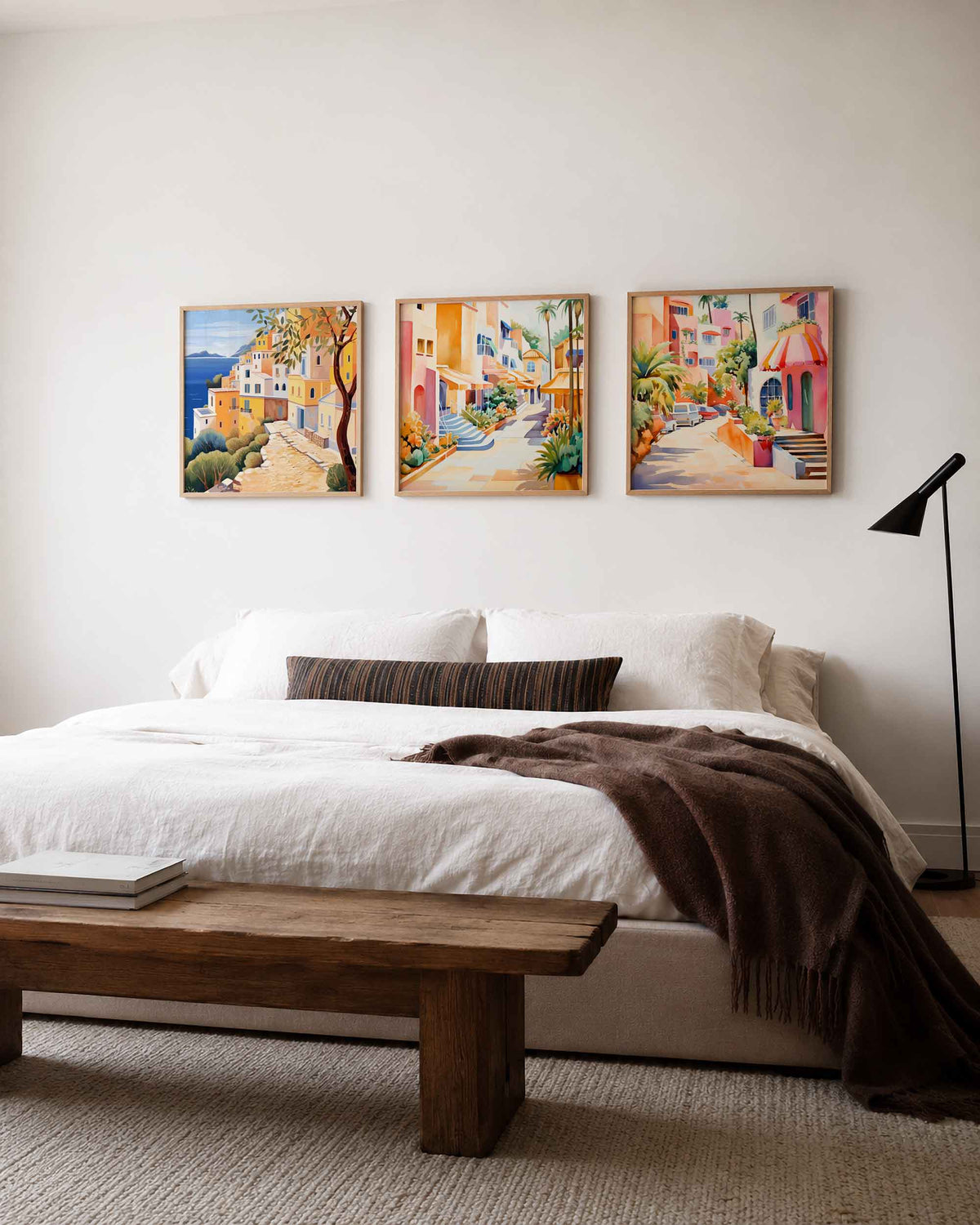Interieurpresentatie van een driedelige vierkante posterset met kleurrijke kustdorp