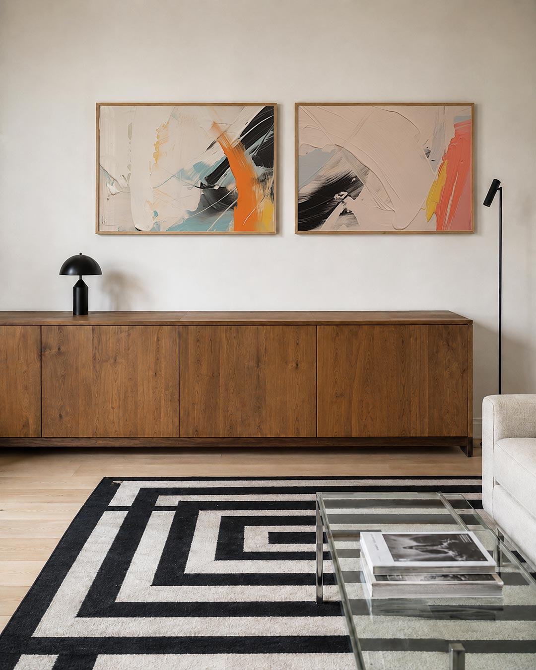 Twee liggende posters met dikke, vloeiende kleurvlakken in wit, oranje en blauw, aan de muur in een interieur