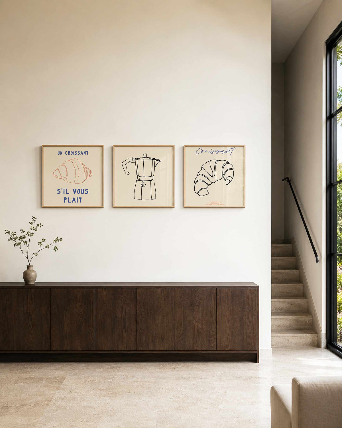 Interieurpresentatie van een driedelige vierkante posterset met croissant en koffie