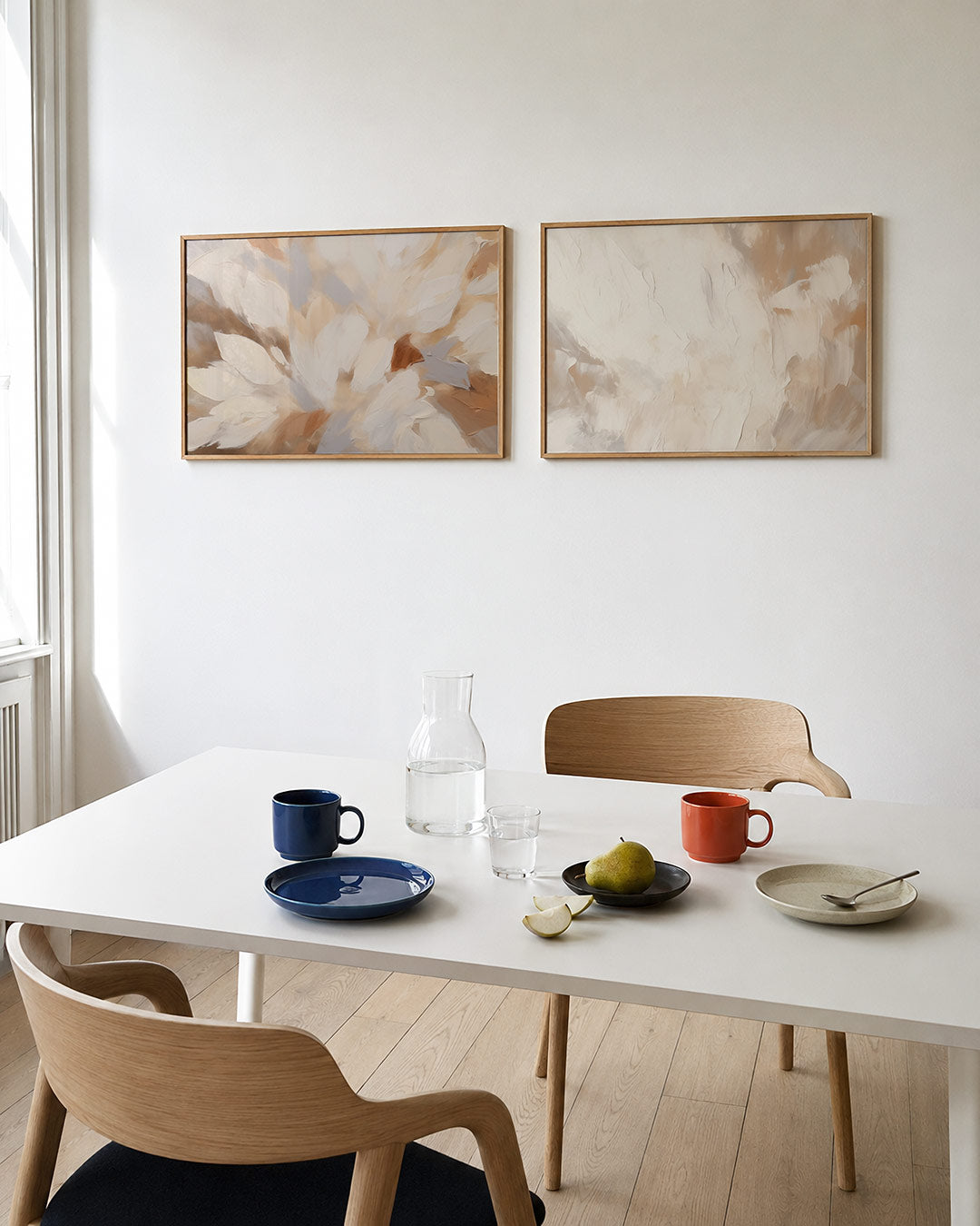 Twee liggende posters met zachte, organische vormen in warme tinten, aan de muur in een interieur