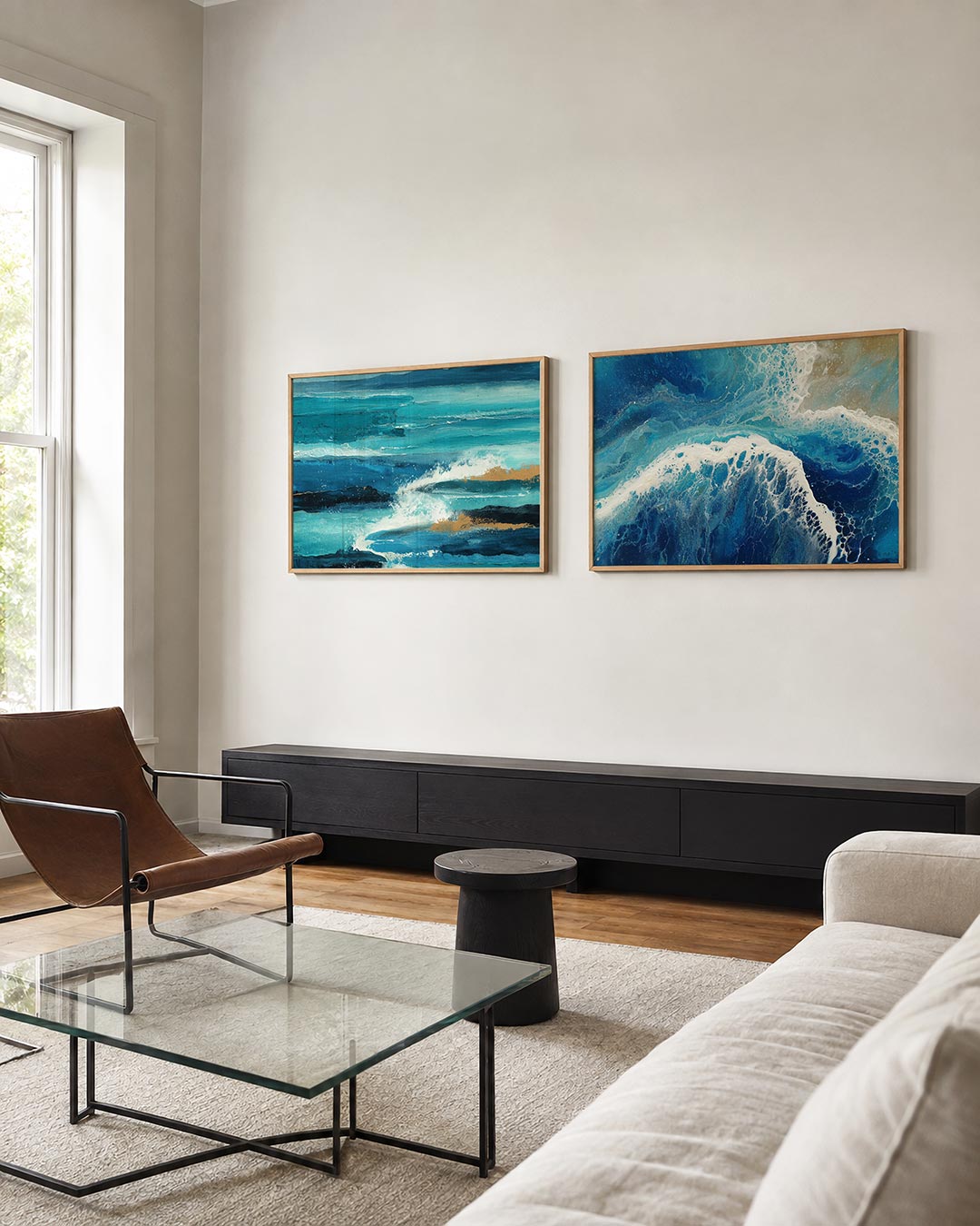 Twee liggende posters met golvende blauwe en turquoise lijnen met spatten van wit en goud, aan de muur in een interieur