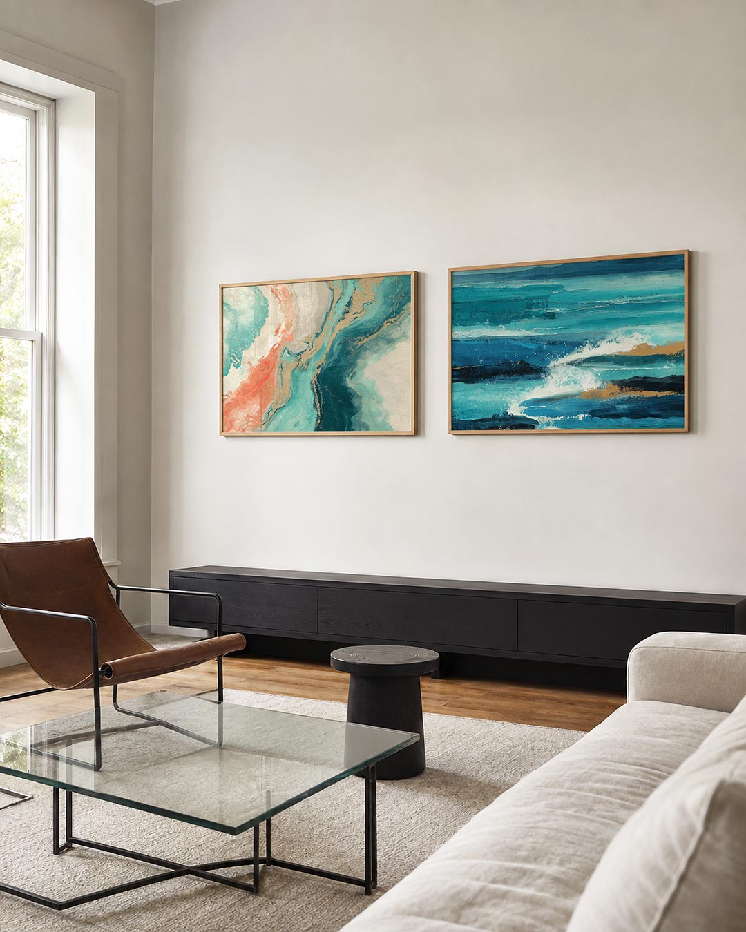 Twee liggende posters met een dynamische mengeling van turquoise, koraal en goud, aan de muur in een interieur