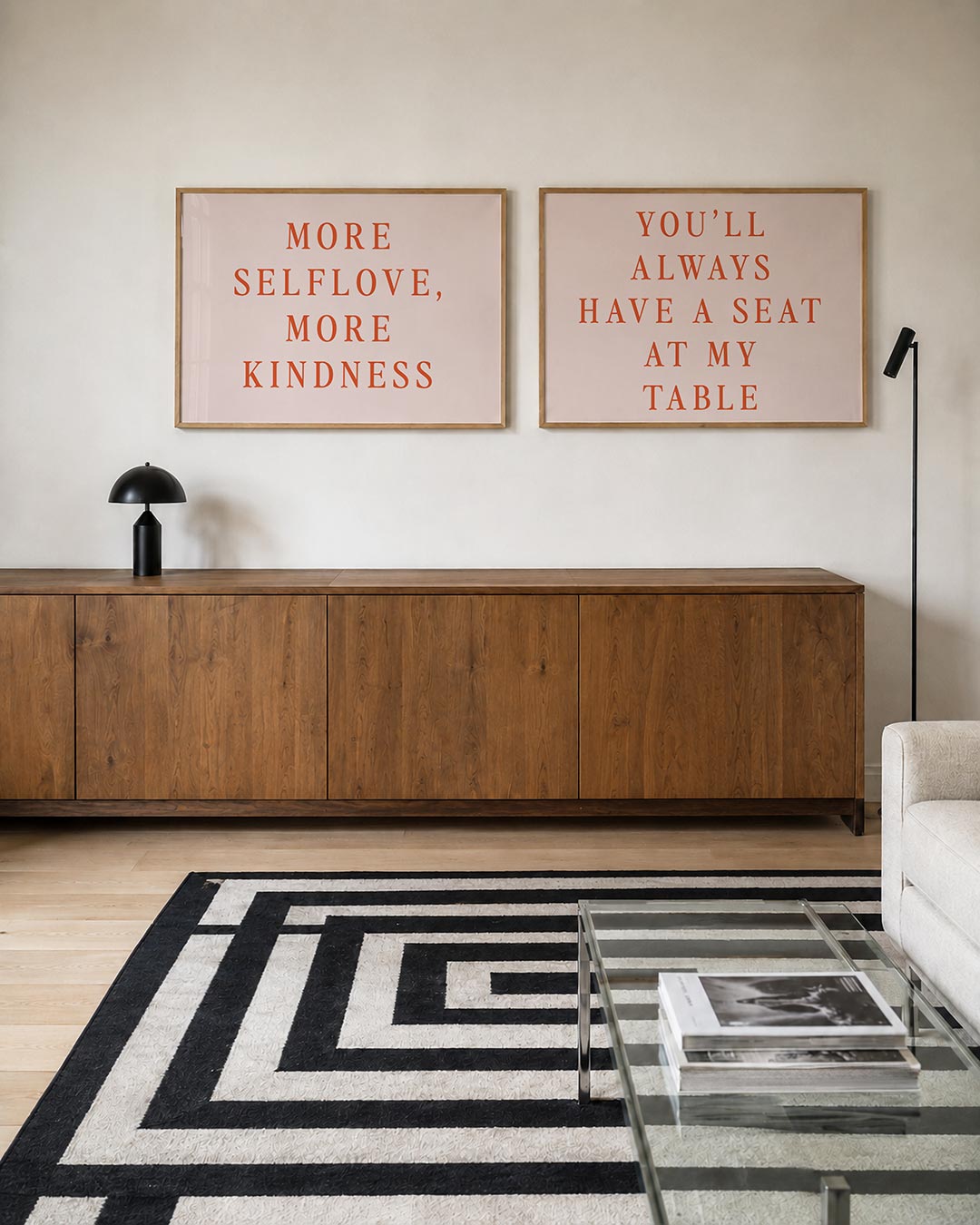 Interieurpresentatie van twee posters met een krachtige tekst in warme oranje letters op een zachte, lichtroze achtergrond
