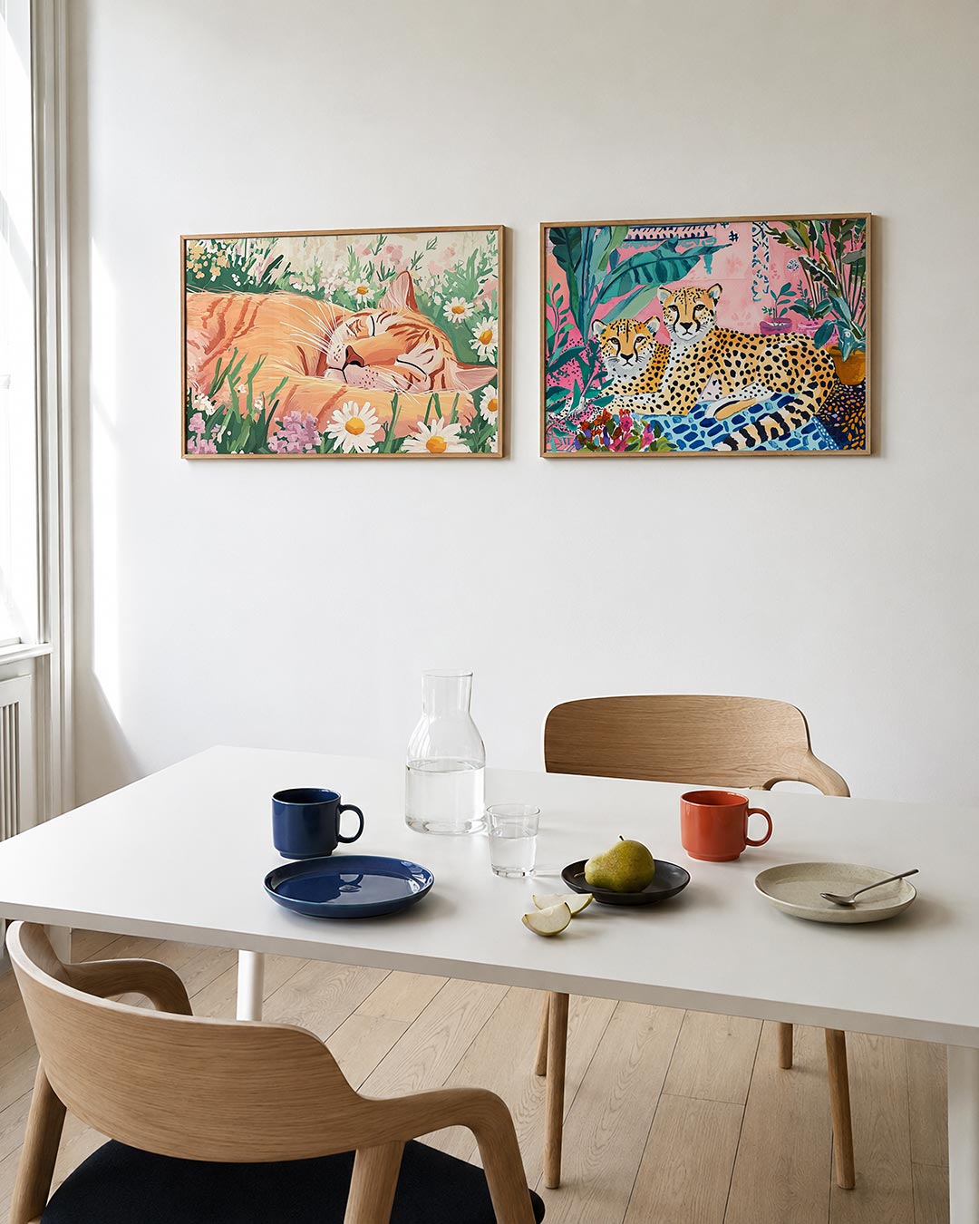 Twee liggende posters met een slapende oranje kat tussen kleurrijke bloemen, aan de muur in een interieur