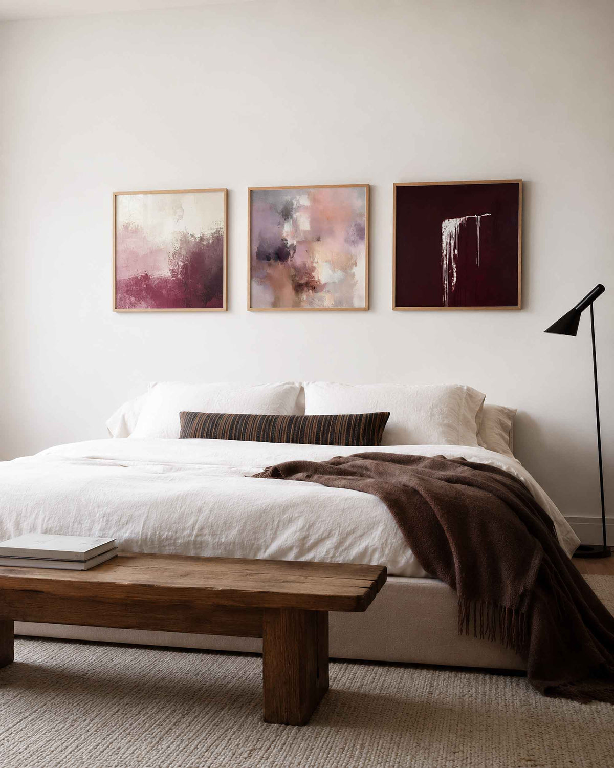 Interieurpresentatie van een driedelige vierkante posterset met abstracte roze bordeaux