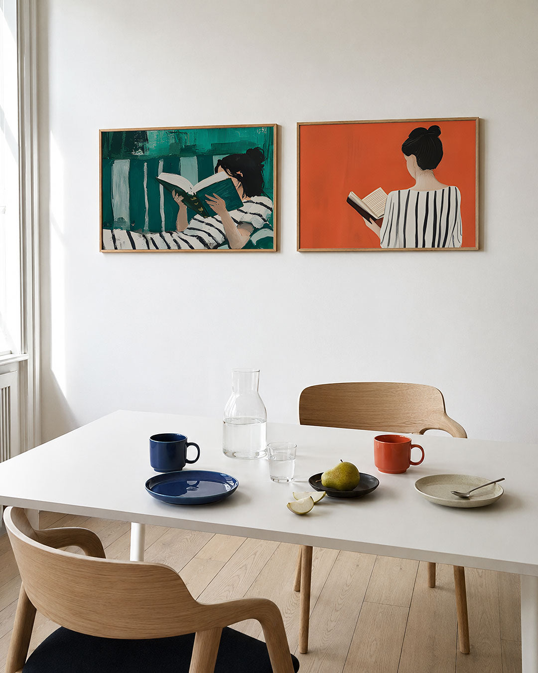 Twee liggende posters met een vrouw met een boek, omgeven door groene en witte kleurvlakken, aan de muur in een interieur