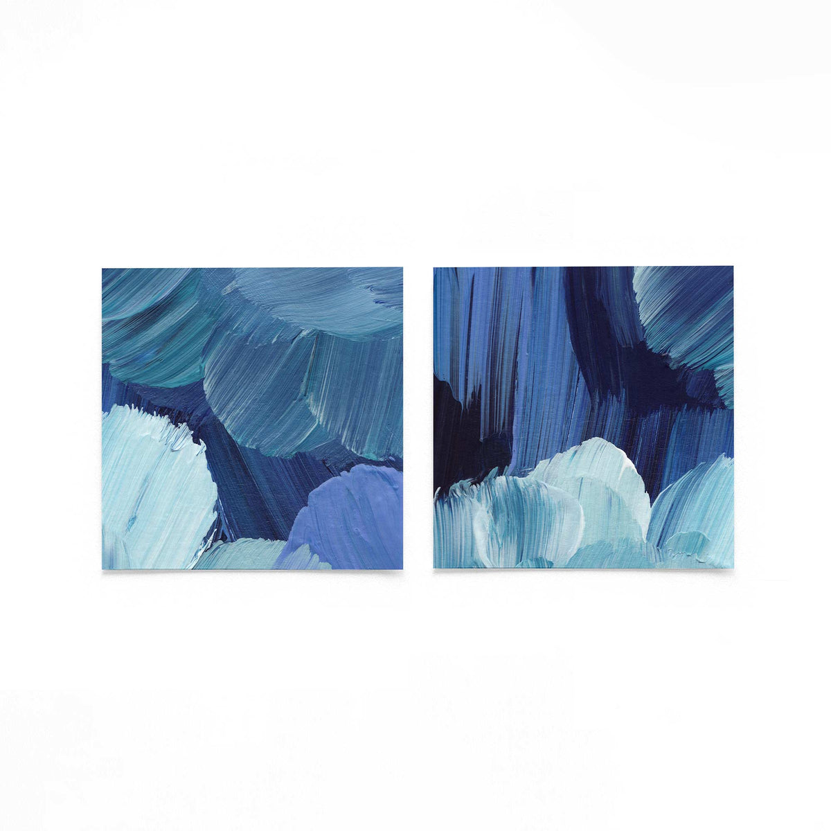 Twee vierkante posters met blauwe penseelstreken op een gebroken witte achtergrond