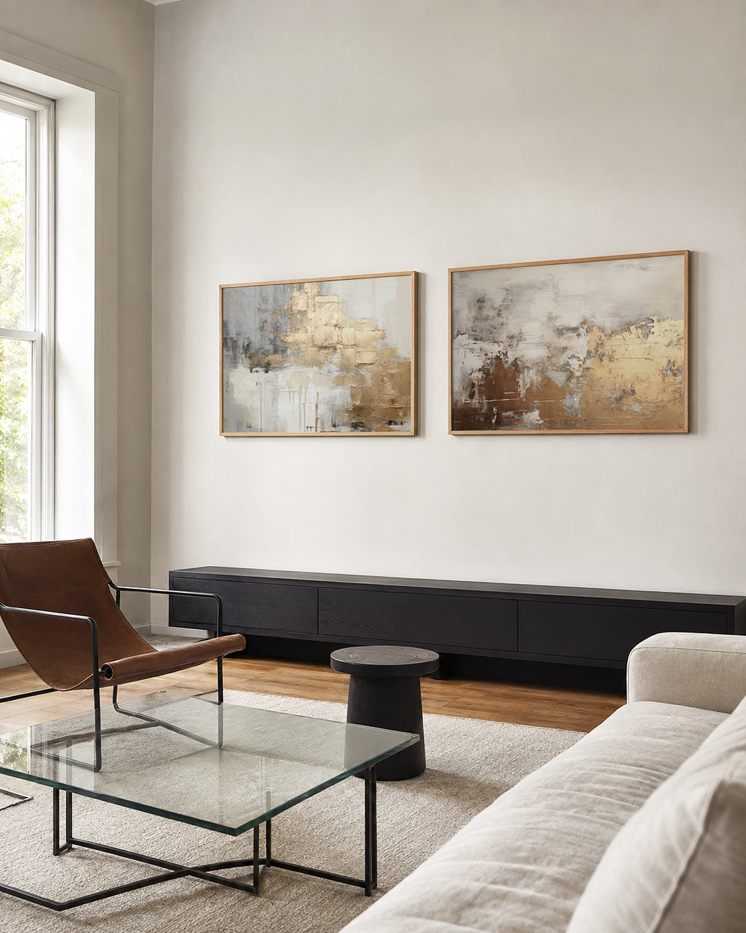 Twee liggende posters met een spel van goud en grijs met ruwe texturen, aan de muur in een interieur