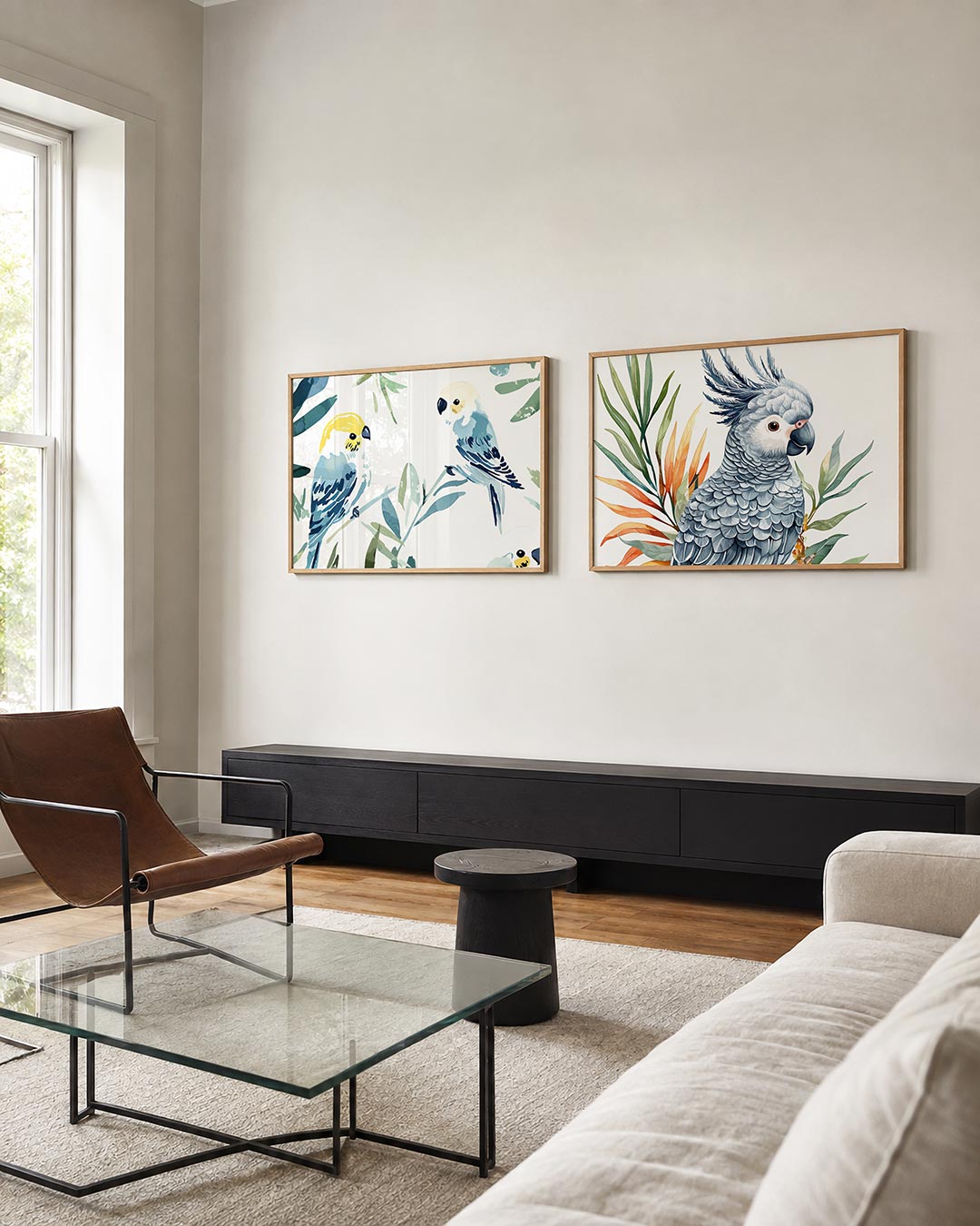 Interieurbeeld met twee liggende posters: twee vogels in zachte blauwtinten met gele accenten, omringd door groene bladeren