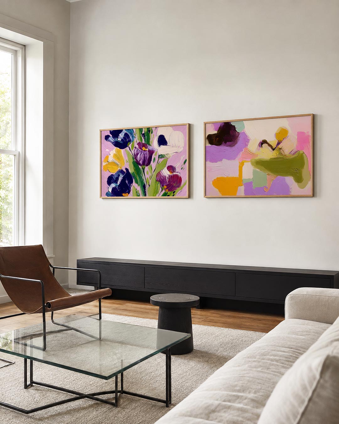 Twee liggende posters met bloemen in paars, geel en blauw op een zachte roze achtergrond, aan de muur in een interieur