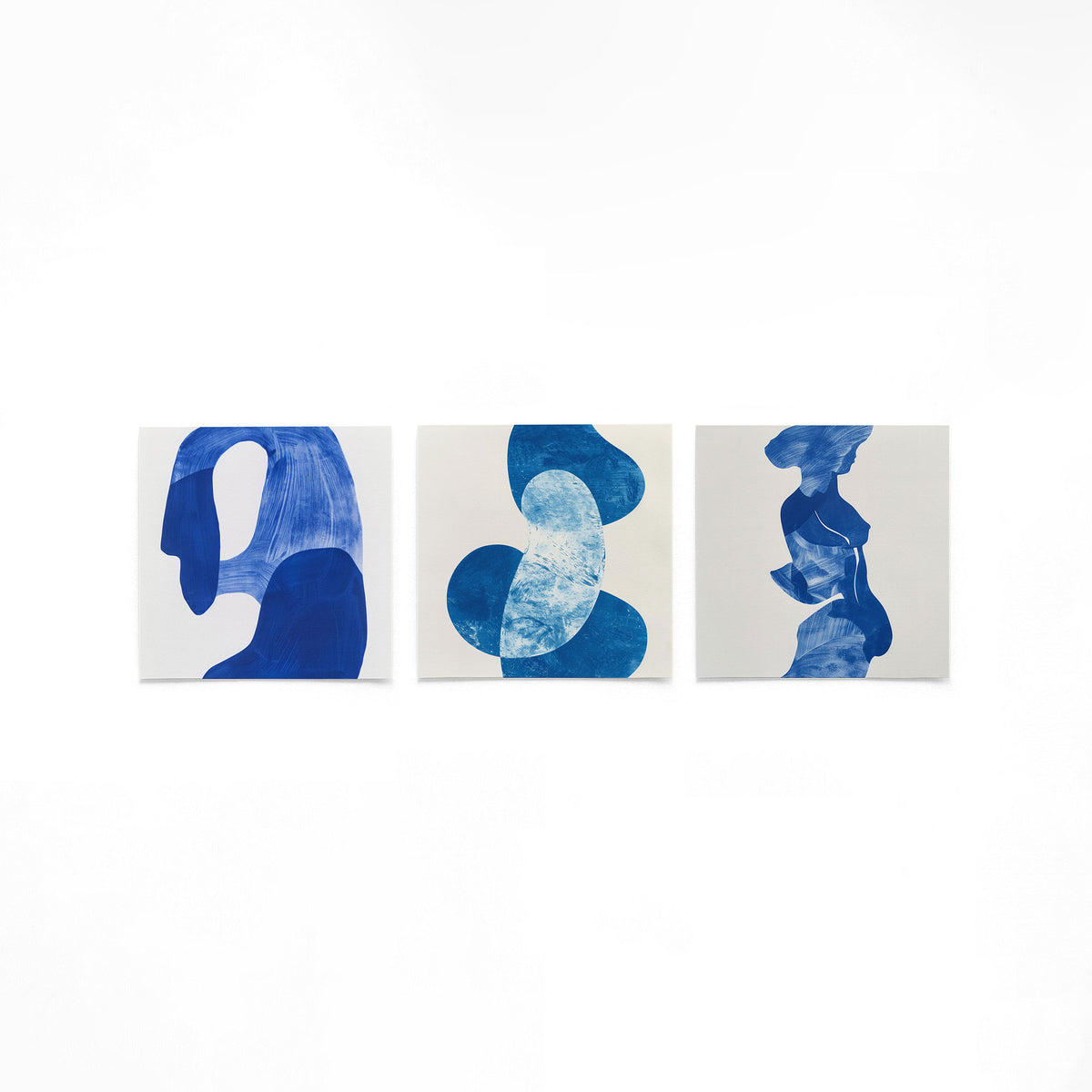 Drie vierkante posters met blauwe abstracte figuren op een gebroken witte achtergrond