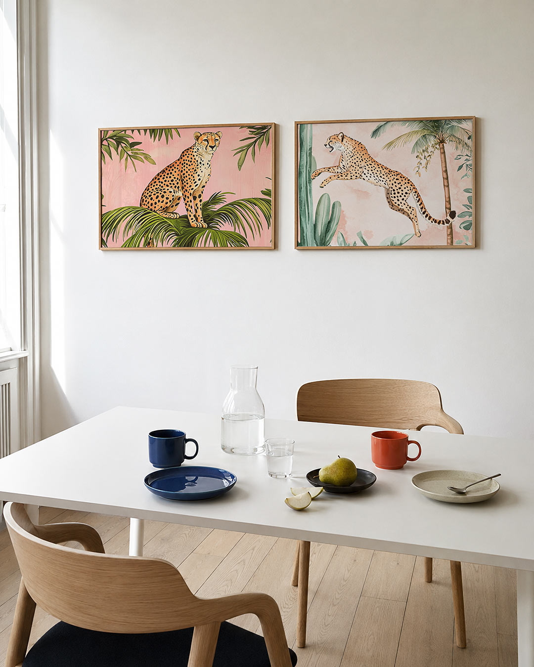 Interieurpresentatie van twee posters met een sierlijke cheetah op groene bladeren tegen een zachte roze achtergrond