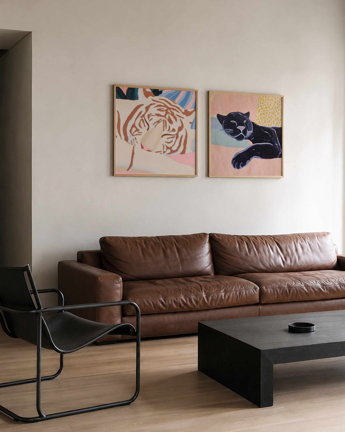 Interieurpresentatie van een tweedelige vierkante posterset met gezichten en zwarte kat