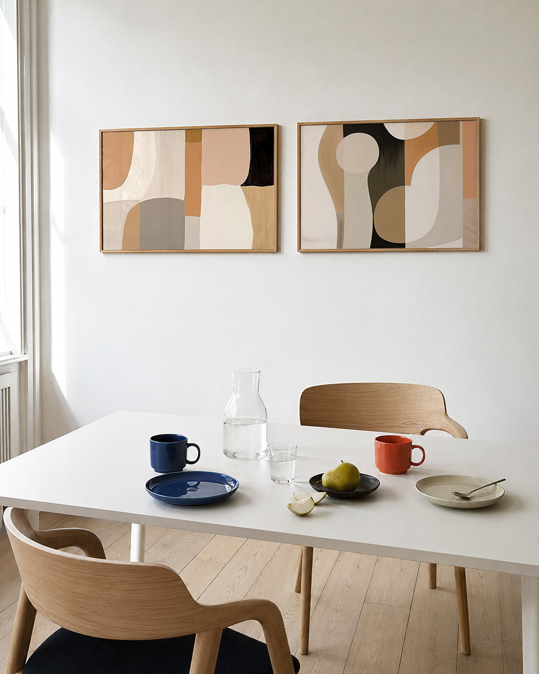 Twee liggende posters met zachte, organische vormen in aardetinten, aan de muur in een interieur