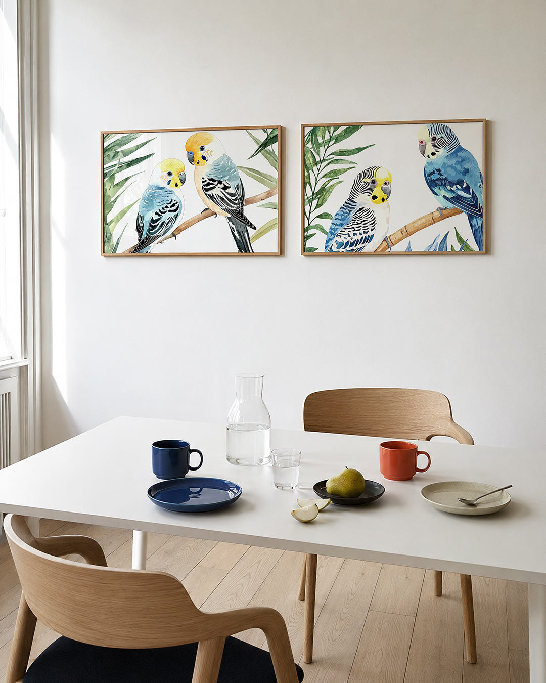 Interieurpresentatie van twee posters met twee kleurrijke vogels op een tak, omringd door groene bladeren