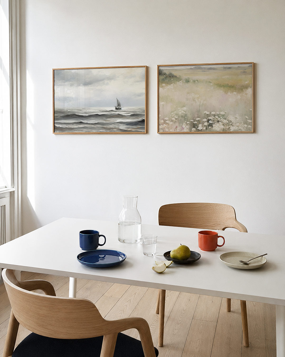 Twee liggende posters met een eenzame zeilboot op een rustige zee, aan de muur in een interieur