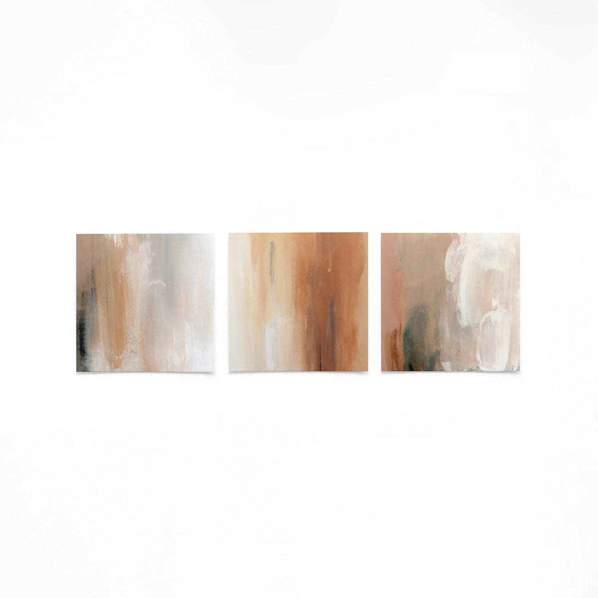 Drie vierkante posters met abstracte aardetinten op een gebroken witte achtergrond