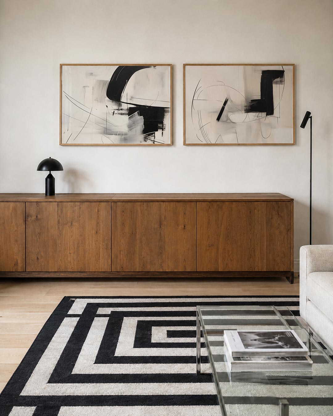 Twee liggende posters met een spel van zwarte en witte vlakken met vloeiende lijnen, aan de muur in een interieur