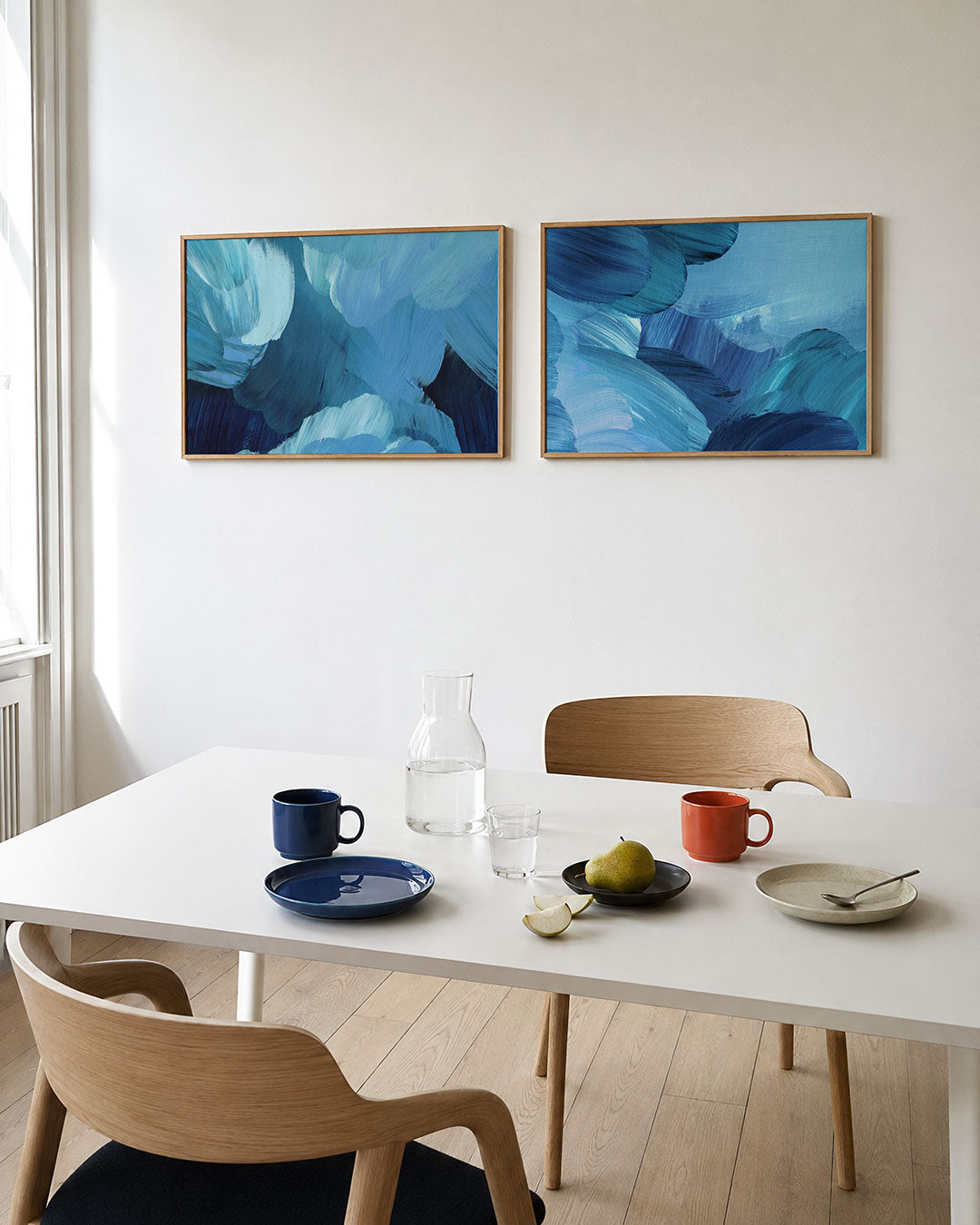 Interieurbeeld met twee liggende posters: deze tweedelige posterset heeft vloeiende blauwe penseelstreken