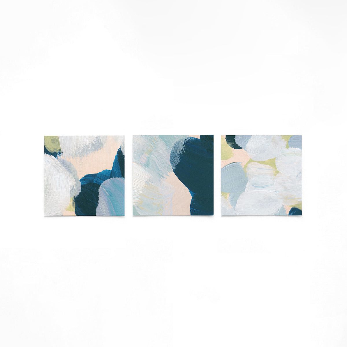 Drie vierkante posters met abstracte penseelstreken op een gebroken witte achtergrond