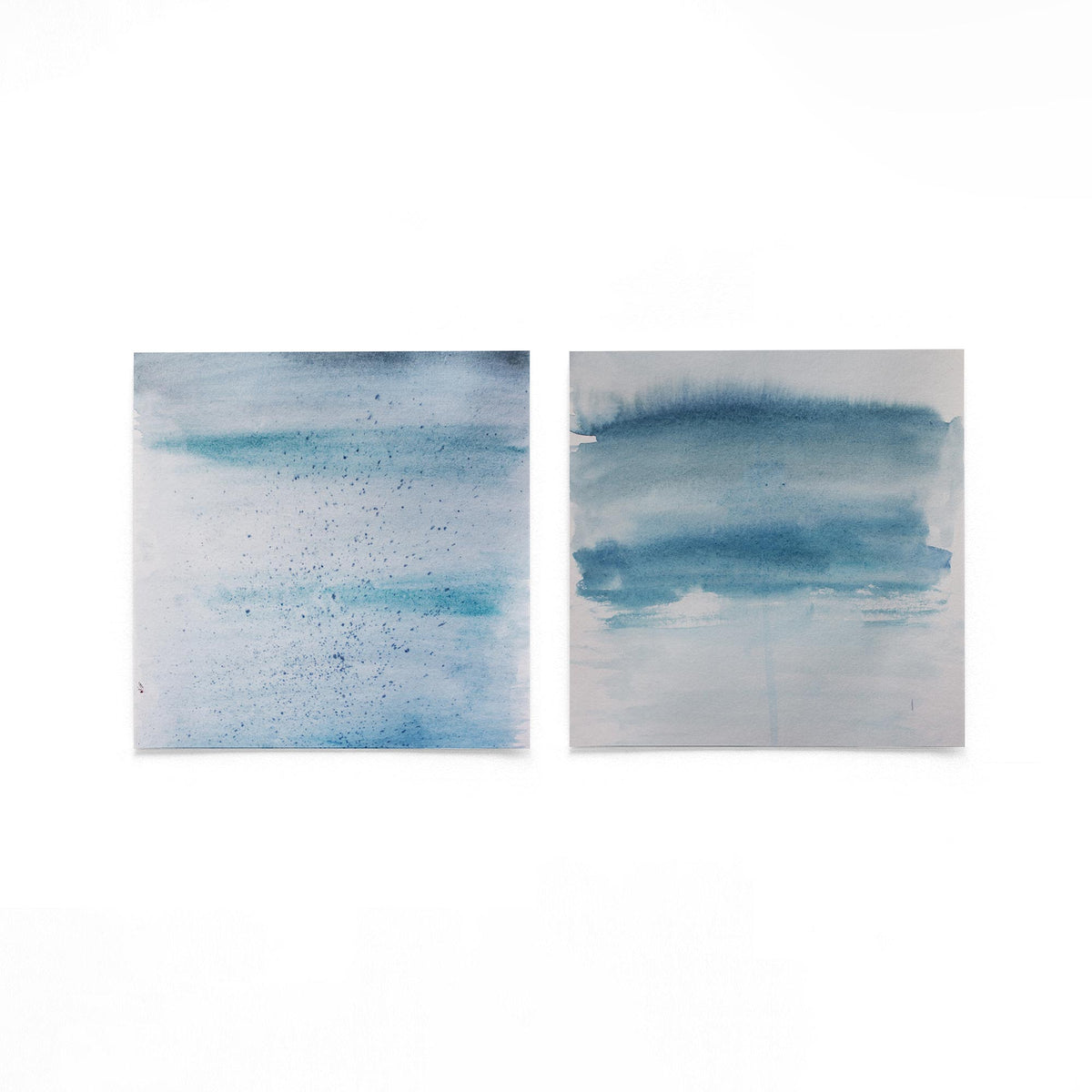 Twee vierkante posters met blauwe aquarelstrepen op een gebroken witte achtergrond