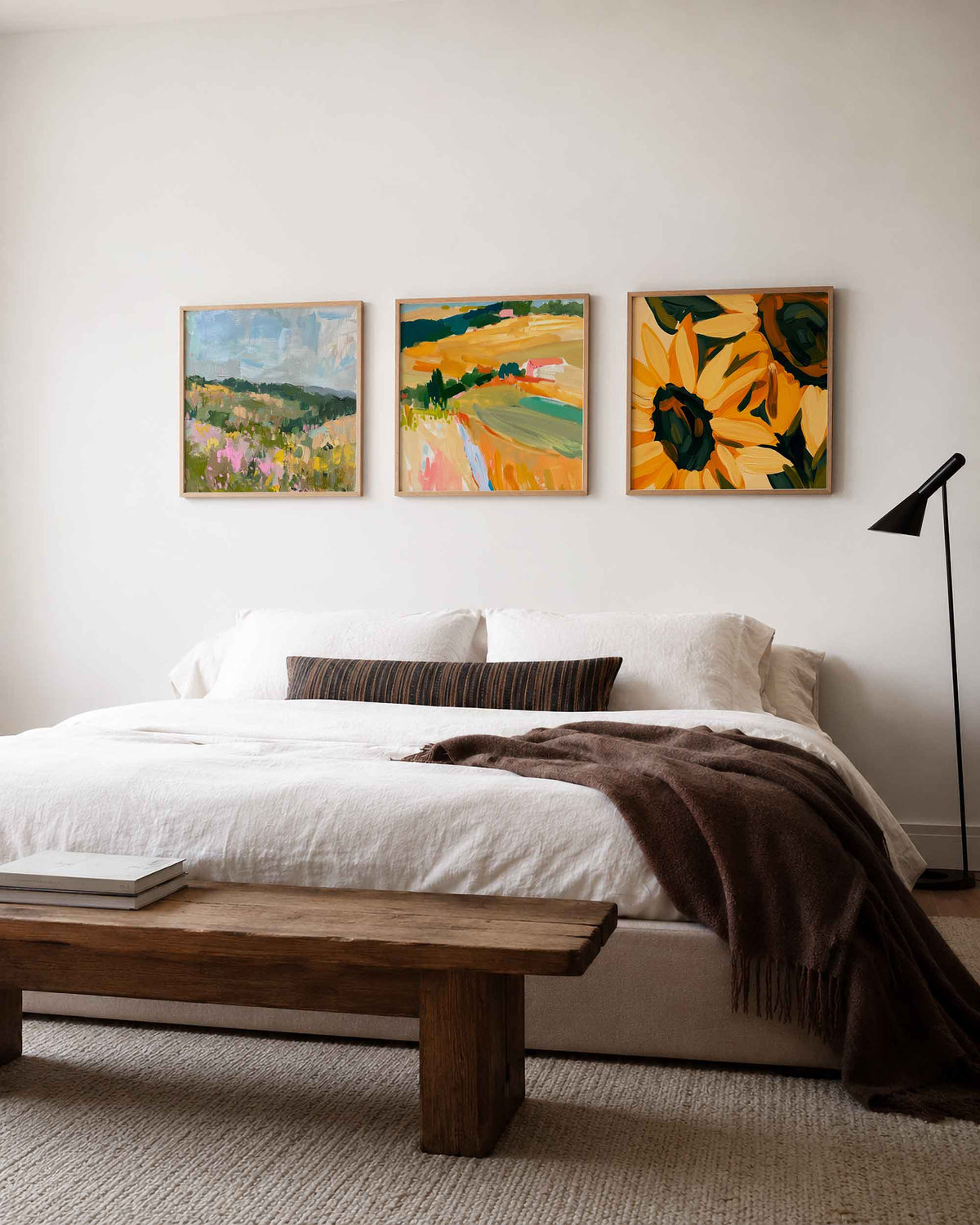 Interieurpresentatie van een driedelige vierkante posterset met kleurrijke landschappen en bloemen
