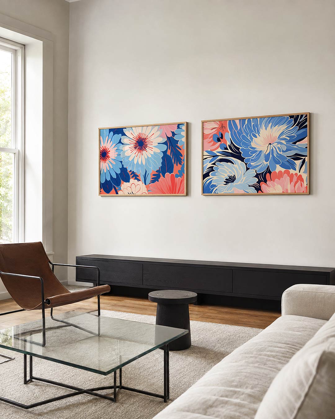 Twee liggende posters met grote bloemen in blauw, roze en wit vullen het beeld, aan de muur in een interieur