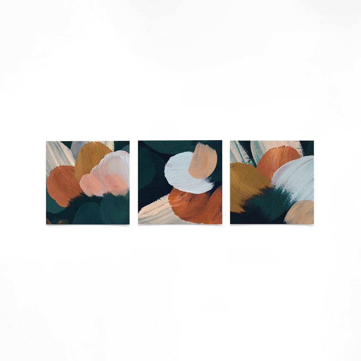 Drie vierkante posters met abstracte penseelstreken op een gebroken witte achtergrond