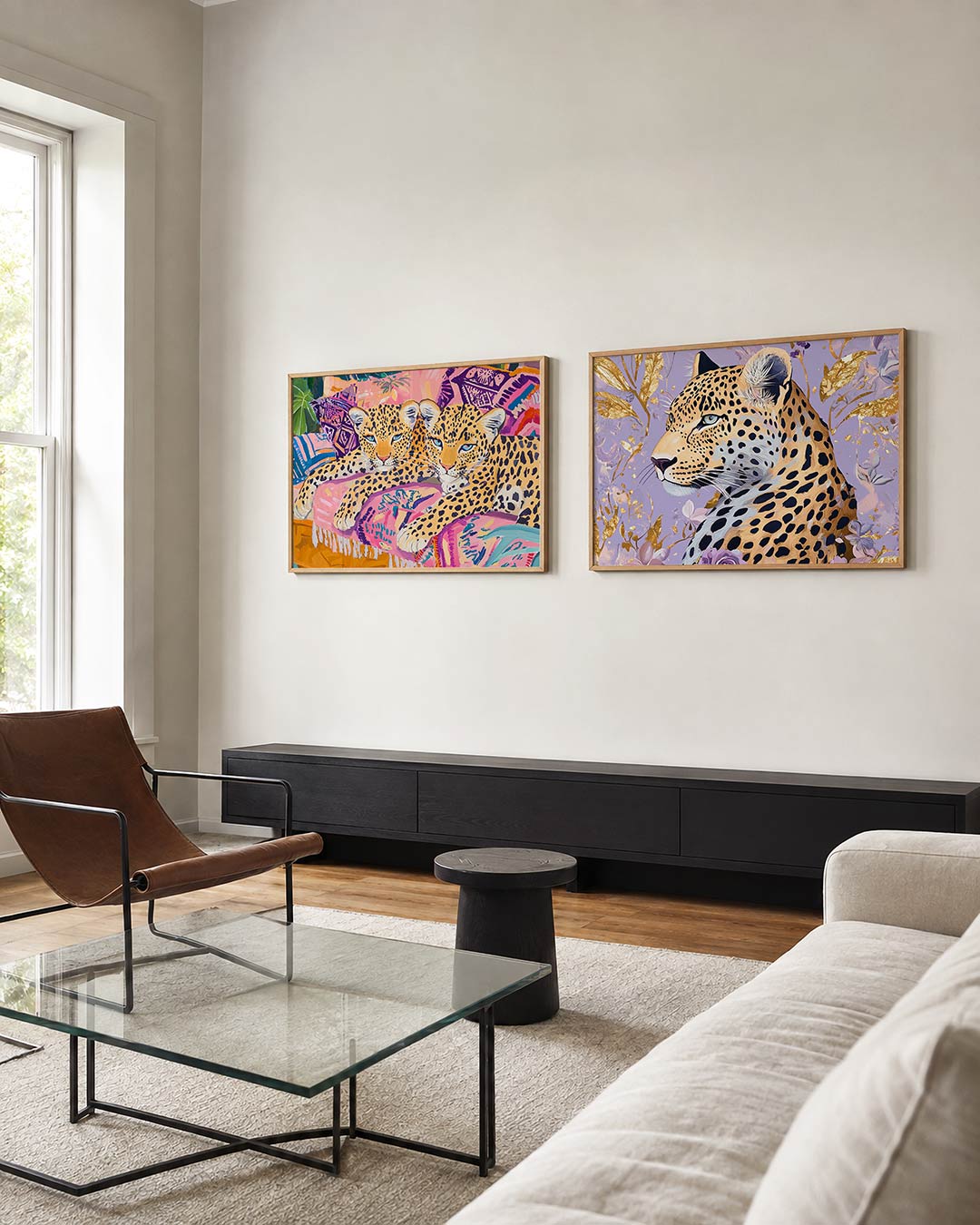 Twee liggende posters met twee luipaarden op kussens met kleurrijke patronen, aan de muur in een interieur