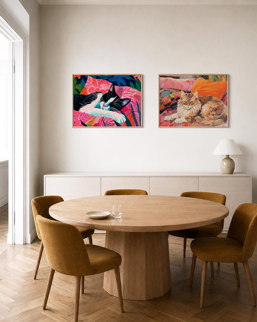 Twee liggende posters met een slapende kat op een bed van levendige roze en blauwe bladeren, aan de muur in een interieur